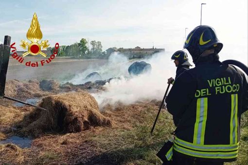 Rotoballe a fuoco su un rimorchio. Vigili del Fuoco al lavoro
