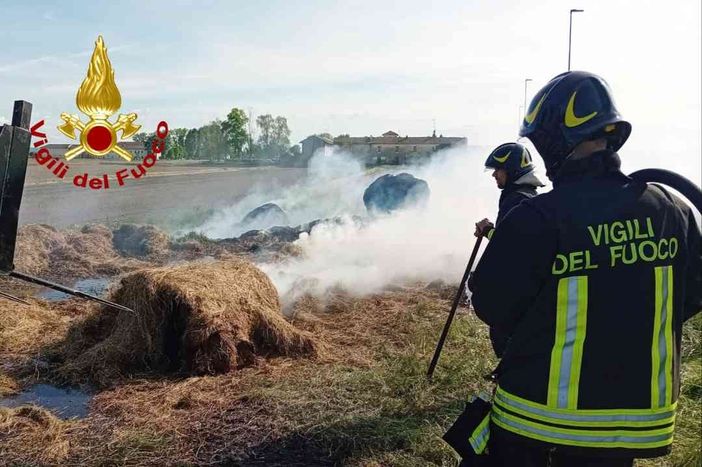 Rotoballe a fuoco su un rimorchio. Vigili del Fuoco al lavoro