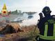 Rotoballe a fuoco su un rimorchio. Vigili del Fuoco al lavoro