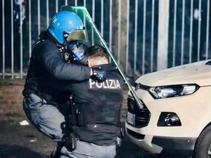L'agente soccorso da un collega dopo essere stato accerchiato e picchiato - Foto dal profilo social di Alberto Cirio